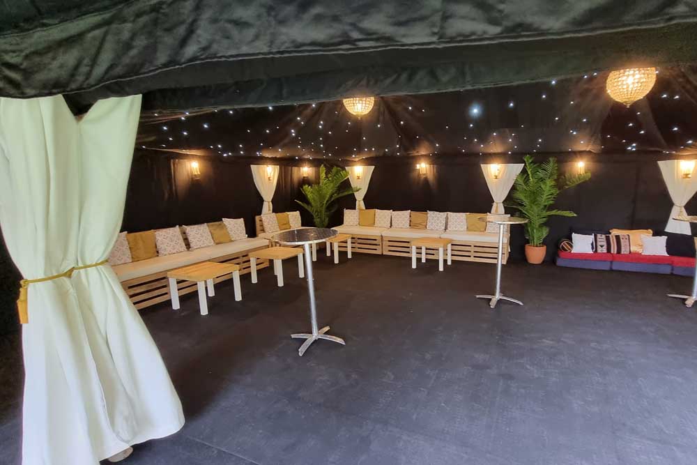 A 9x6m Bedouin Tent with Starcloth Linings and Pallet Bench Seating.