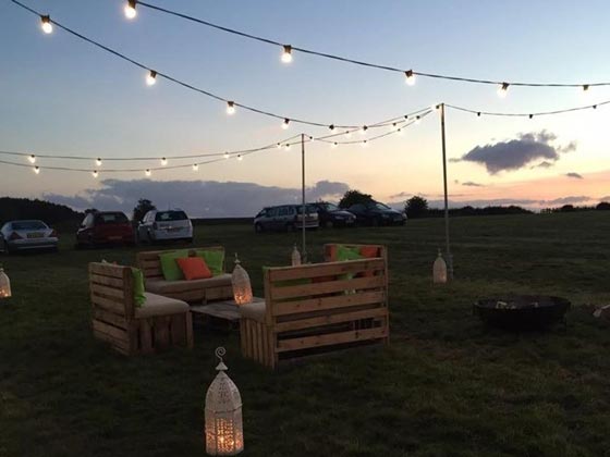 Festoon Lighting Supported by 3 Meter High Scaffold Poles, Illuminating a Festival Themed Wedding