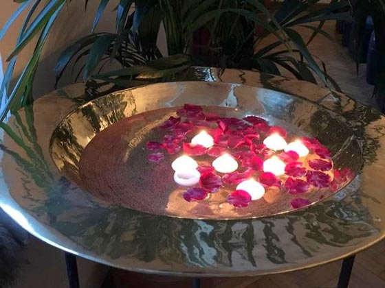 A Giant Polished Brass Dish on a Stand, Filled with Water, Floating Rose Petals, and Floating Candles
