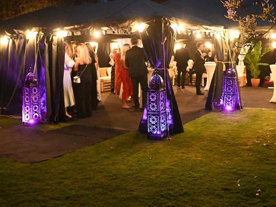 Three Large Moroccan Candle Lanterns Lit Up with Purple RGB Uplighters at a Springtime Black Tie Event