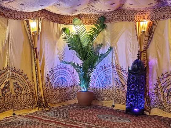 A 6ft Faux Palm Tree Next to a Large Moroccan Candle Lantern, Both Illuminated with RGB LED Uplights - Inside an Arabian Tent