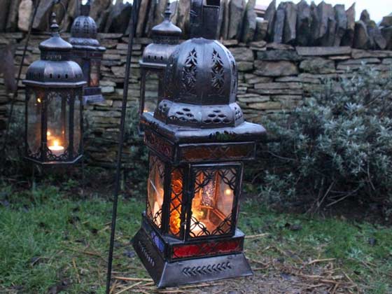A Group of Moroccan Iron and Colorful Glass Lanterns Hanging from Poles