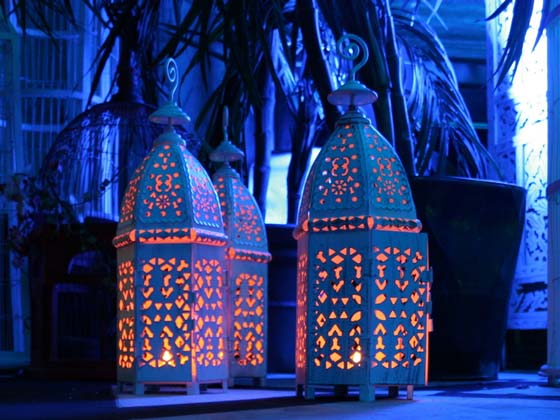 Three Small Cream Candle Lanterns Lit with Tea Light Candles
