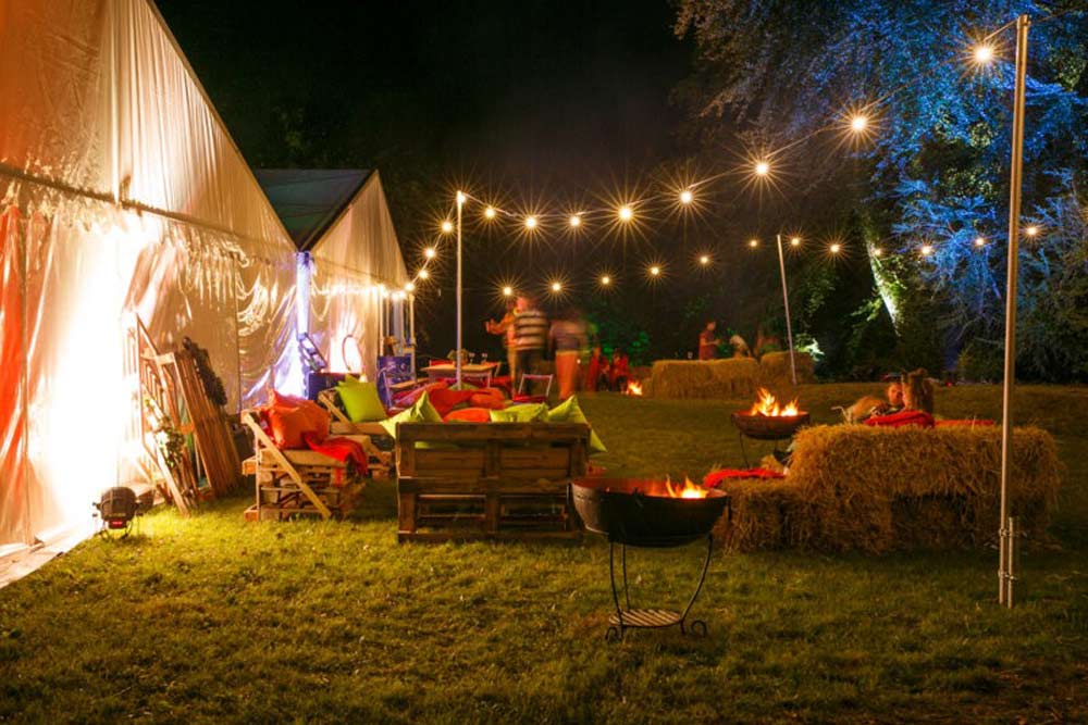 Festoon lanterns on 3 meter high poles illuminating outdoor seating area.