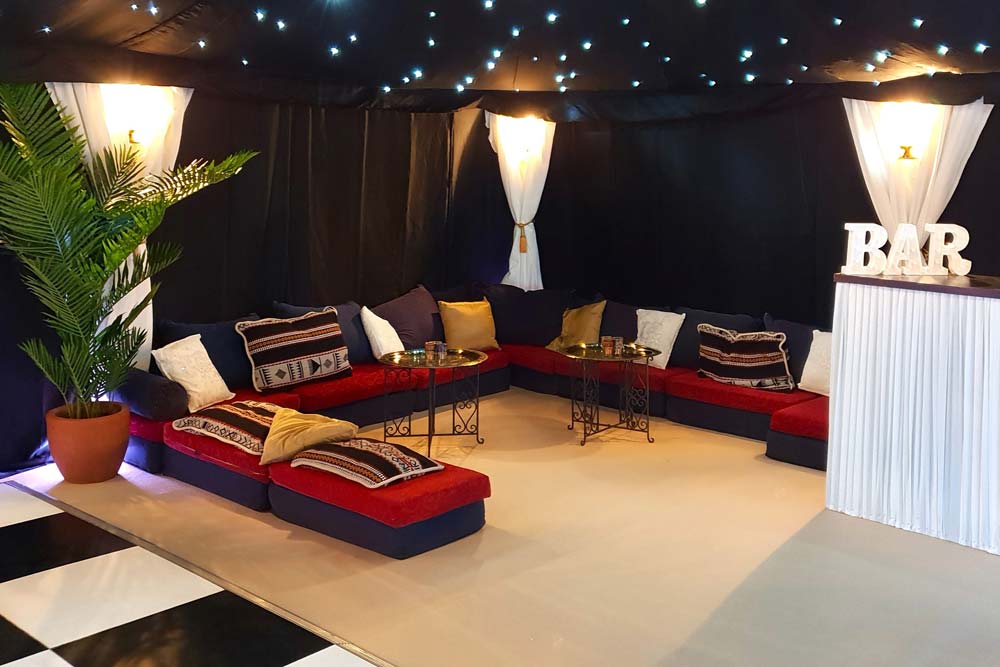 low-level chillout seating inside a starcloth party tent