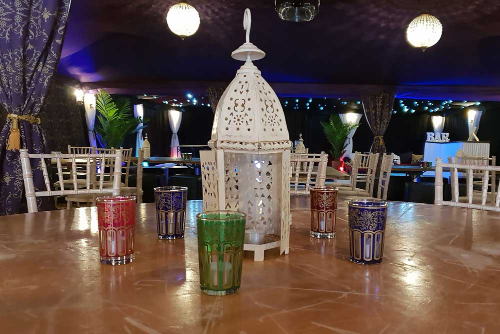 Indoor Moroccan lanterns and tea glasses as table decorations.