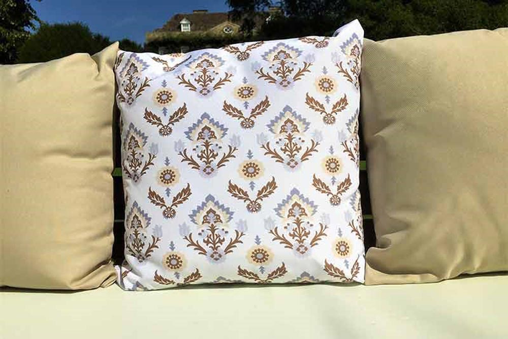 Three water resistant outdoor scatter cushions on a pallet bench.