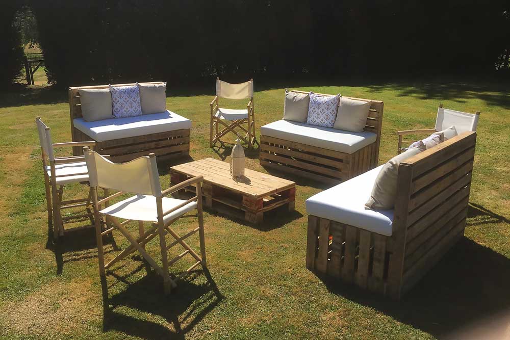 Bamboo Director's chairs with cream seats and pallet benches providing social outdoor seating.