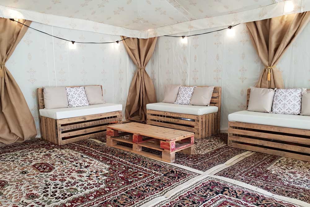 Pallet Furniture Inside an Arabian Tent with Jasmine Lining and Cream Persian Carpets