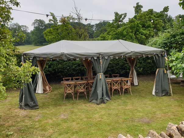 A rustic party tent set for an alfresco 30th birthday dinner party in Chipping Campden, Gloucestershire.
