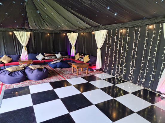 A black and white dancefloor in a starcloth party tent.