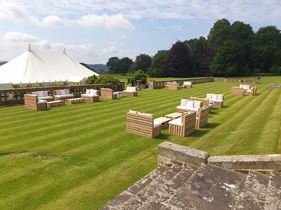 Pallet furniture outside of a large tradtional marquee of a corporate event.