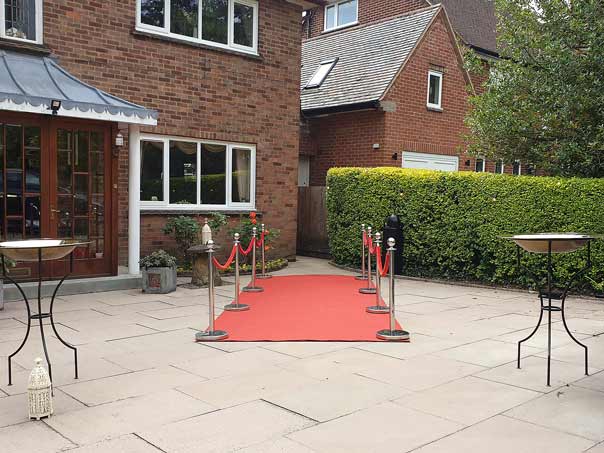A red carpeted entrance leading to the back garden marquees.