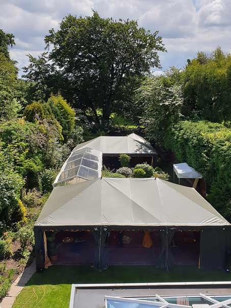 A view from above of lots of marquee joined together filling a clients back garden.
